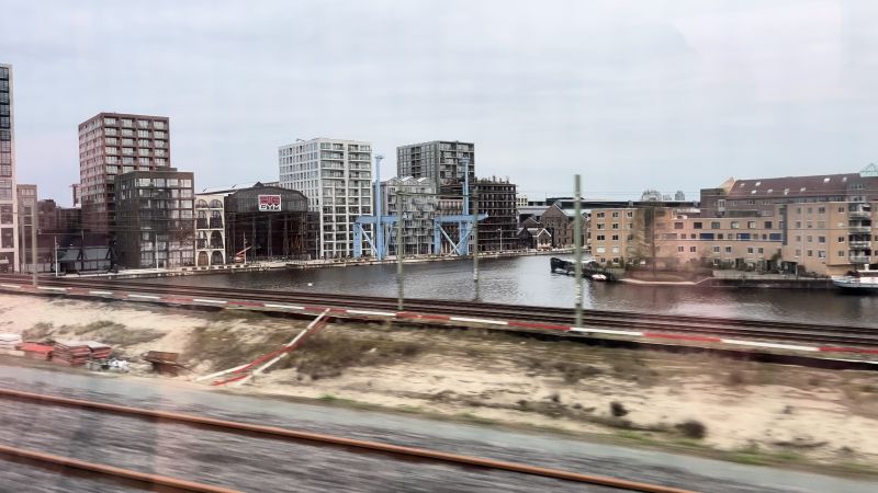 Blick aus dem Zugfenster auf einen Fluss in Amsterdam